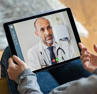 Patient conferring with doctor via computer screen